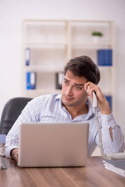 Genç işadamı ve işyerinde çok fazla iş var.