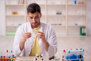Young chemist sitting at the lab