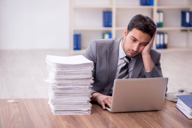 Genç bir çalışan ve ofiste çok fazla iş var.