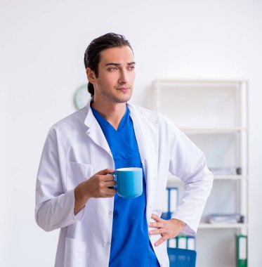 Klinikte çalışan genç erkek doktor.