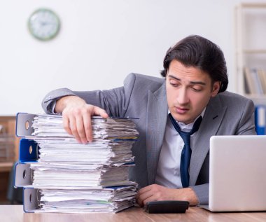 Genç erkek çalışan aşırı işten memnun değil.