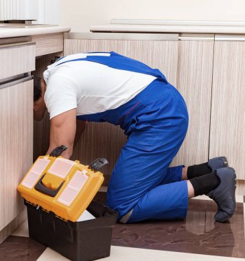 Mutfakta çalışan genç tamirci.