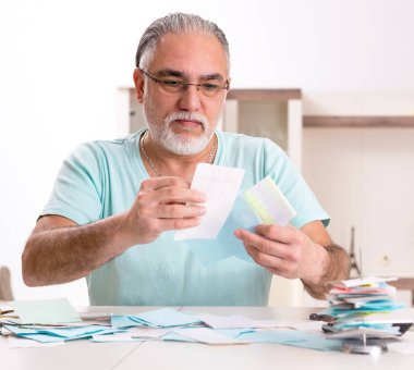 Bütçe planlama konseptinde beyaz sakallı yaşlı adam.