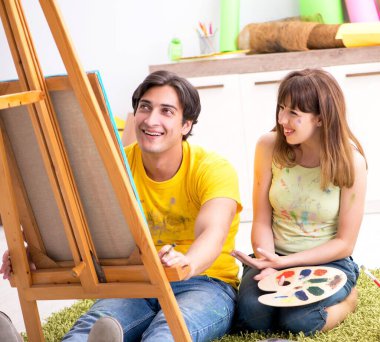 Genç çift evde resim yapmaktan zevk alıyor.