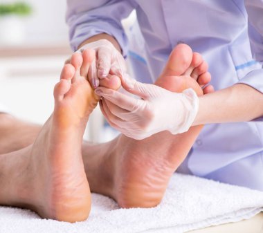 The podiatrist treating feet during procedure clipart