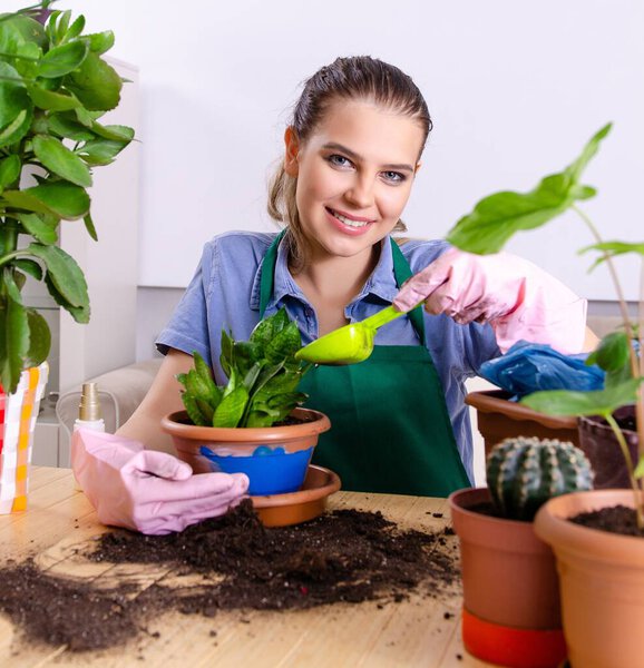 The young female gardener with plants indoors
