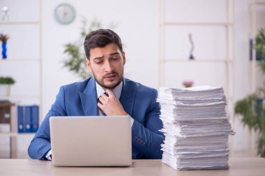 Genç bir çalışan ve ofiste çok fazla iş var.