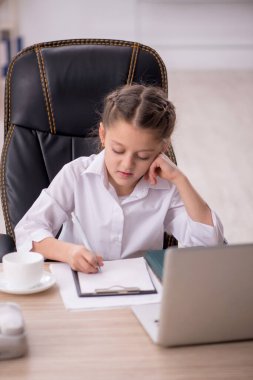 Küçük kız sınıfta oturuyor