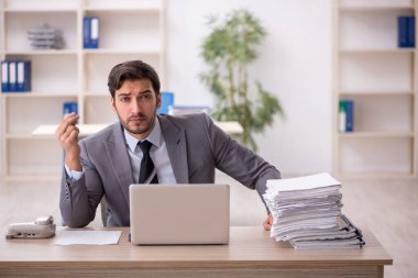 Genç işadamı ve ofiste çok fazla iş var.