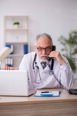 Teletıp konseptinde yaşlı bir doktor.