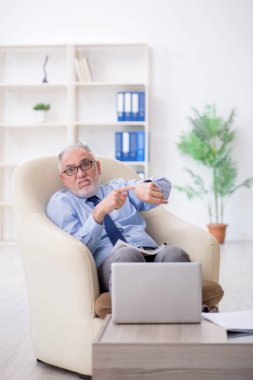 Koltukta oturan eski bir çalışan.