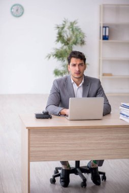 Young employee and too much work at workplace