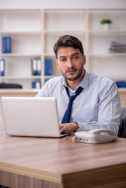 Young employee and too much work at workplace