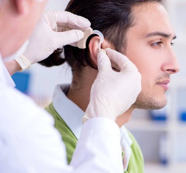 İşitme sorunu olan erkek hasta doktor otorhinolaryngologist 'i ziyaret ediyor.