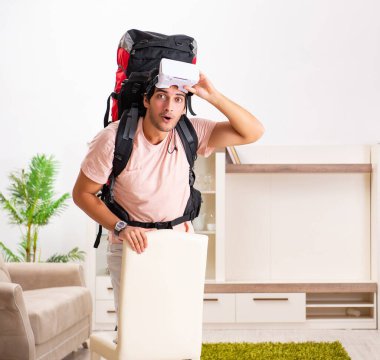 The young male tourist with virtual glasses preparing for trip