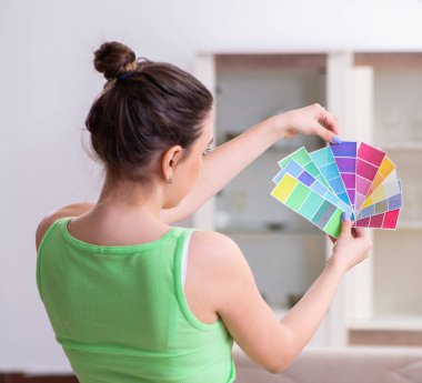 Evinde tadilat yapan genç ve güzel bir kadın.