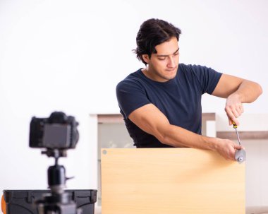 Genç erkek tamirci blogu için video kaydediyor.