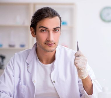 Laboratuvarda çalışan genç erkek kimyager.