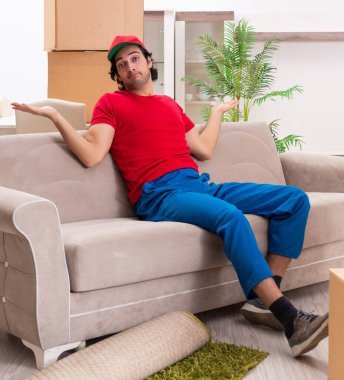 İçeride çalışan kutularla çalışan genç bir erkek müteahhit.