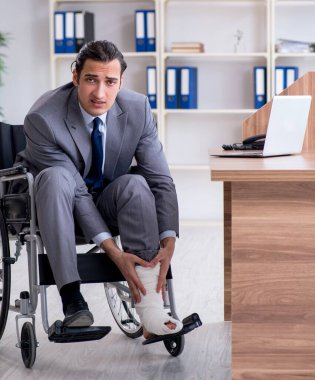 Ofisteki tekerlekli sandalyedeki erkek çalışan.