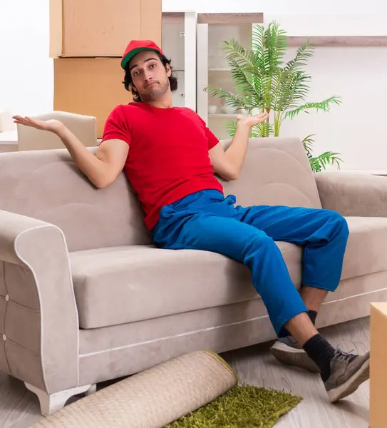 İçeride çalışan kutularla çalışan genç bir erkek müteahhit.