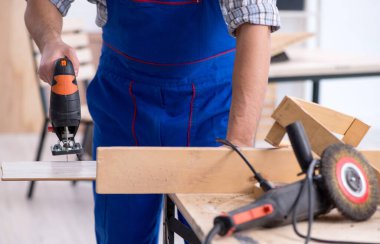 İçeride çalışan genç erkek marangoz.