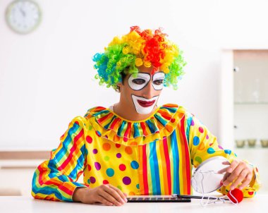 Erkek palyaço evde performansa hazırlanıyor.