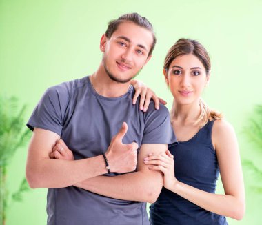 Spor salonundaki genç kadın ve erkek.