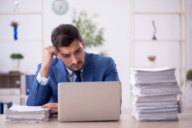 Genç bir çalışan ve ofiste çok fazla iş var.