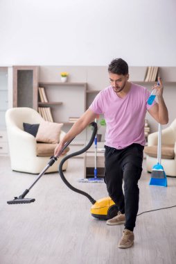 Genç müteahhit evi temizliyor.