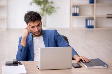 Genç çalışan işyerinde oturuyor.