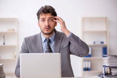 Genç bir çalışan ve ofiste çok fazla iş var.