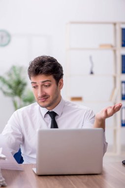 Young employee and too much work at workplace