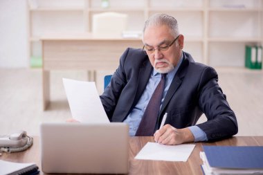 Ofiste çalışan eski bir işadamı.