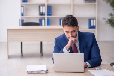 Genç işadamı işyerinde oturuyor.