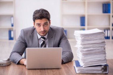 Genç bir çalışan ve ofiste çok fazla iş var.
