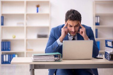 Genç işadamı ve işyerinde çok fazla iş var.