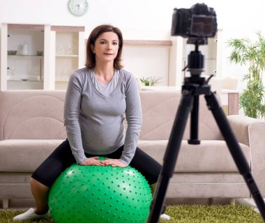 Hamile kadın blogcu fiziksel egzersiz yapıyor.