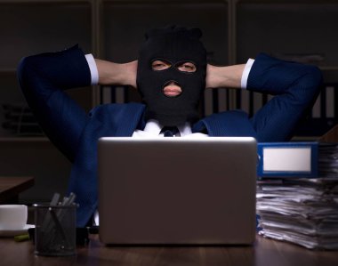 Erkek çalışan gece ofiste bilgi çalıyor.