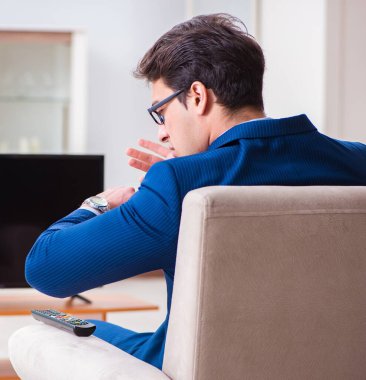 Ofiste televizyon izleyen iş adamı.