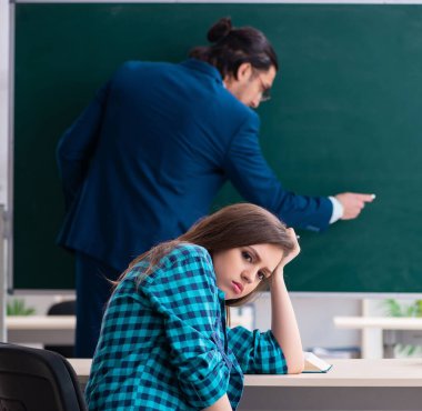 Sınıftaki genç, yakışıklı öğretmen ve bayan öğrenci.