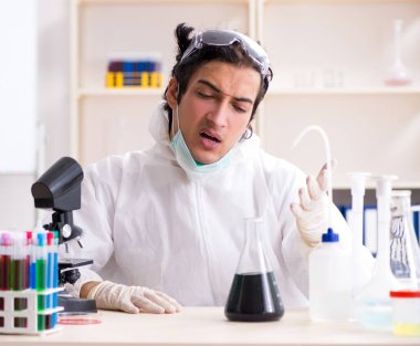 Laboratuvarda çalışan genç yakışıklı kimyager.