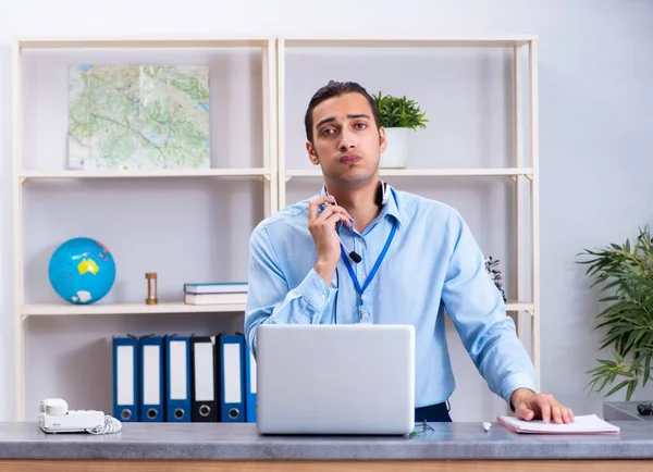 The young male travel agent working in the office