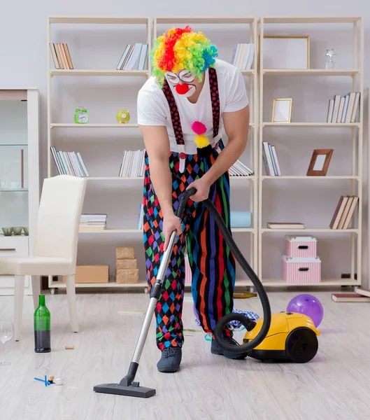 The funny clown doing cleaning at home
