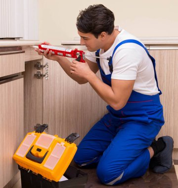 Mutfakta çalışan genç tamirci.