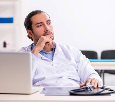 Klinikte çalışan yakışıklı genç bir doktor.