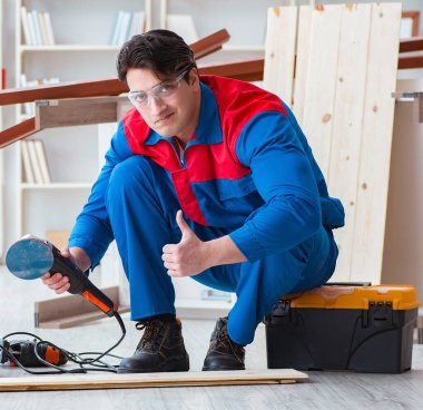 Genç marangoz tahta kalaslarla çalışıyor.