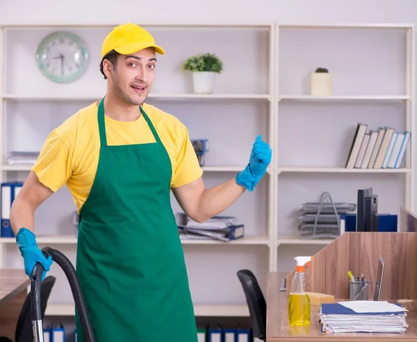 Genç erkek müteahhit ofisi temizliyor.
