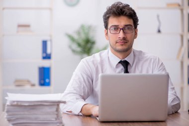 Young employee and too much work at workplace