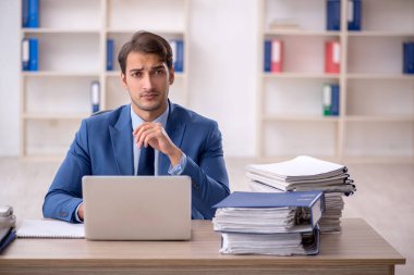 Genç işadamı ve ofiste çok fazla iş var.